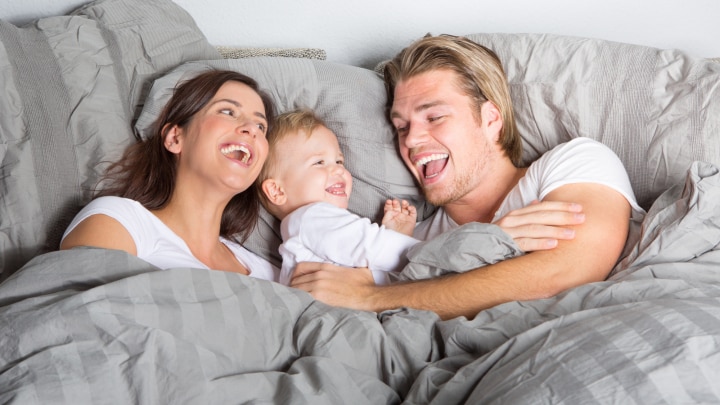 paar und baby im bett
