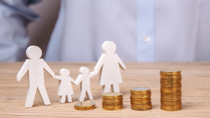 familien-pappfigur-und-münzstapel